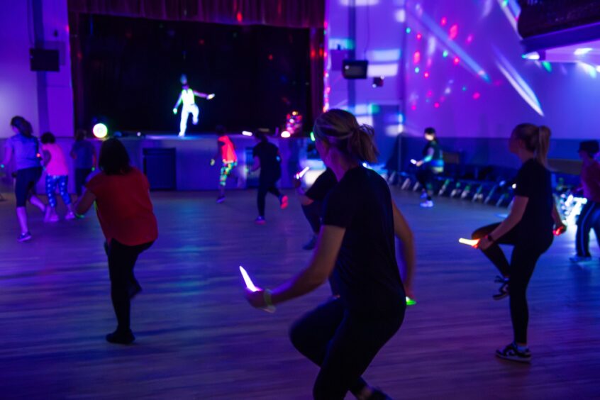 Attendees workout with glowsticks at a Clubbercise class in Aberdeen.