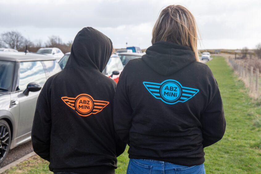 Two members of the Aberdeen Mini Owners Club wear black hoodies bearing the Mini logo