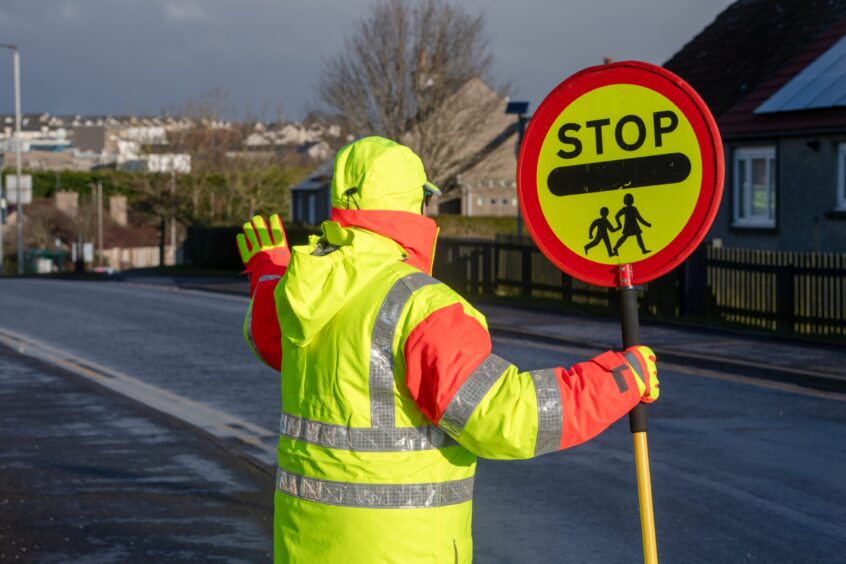 School crossing patroller holding stop sign