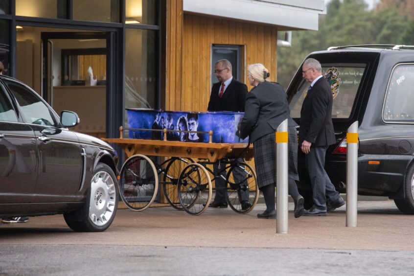 The 10-year-old's coffin is brought in to the funeral hall on a wagon. 
