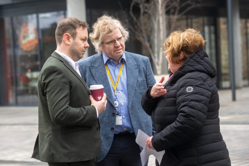 Council co-leader Ian Yuill, in blue, with SNP councillor Ciaran McRae, speaking to a Torry Raac protestor. Image: Kath Flannery/DC Thomson