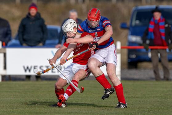 Kinlochshiel's Archie MacRae resists the challenge from Calum Grant, Kingussie, right. Image: Neil G Paterson.