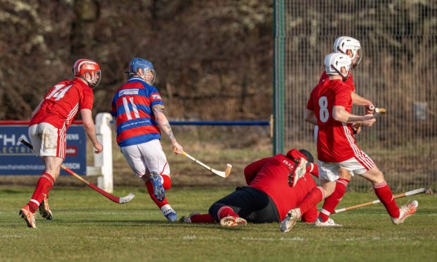 Kingussie No. 11 Dylan Borthwick watches his shot his the back of the net for the only goal of the game against Kinlochshiel in the Mowi Premiership. Image: Neil Paterson.