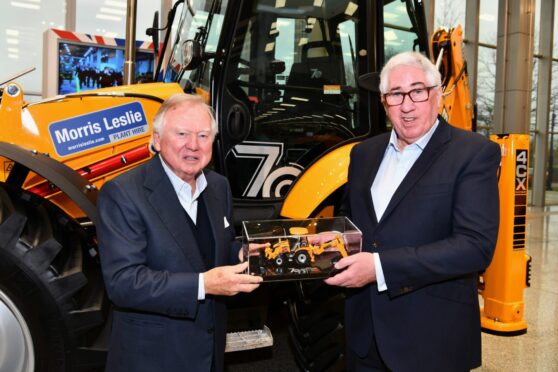 JCB chairman Anthony Bamford, left, presents Morris Leslie with a special scale model version of the Platinum Edition backhoe loader produced to mark the JCB machine’s 70th birthday.