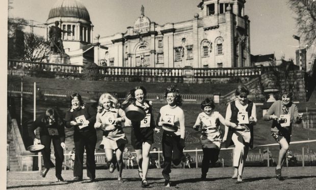 1973: Off to a flying start in the Shrove Tuesday pancake race at Union Terrace Gardens, Aberdeen. Armed with pancakes of all shapes and sizes the nine women sprinted along for 100 yards tossing pancakes as they ran. Image: DC Thomson