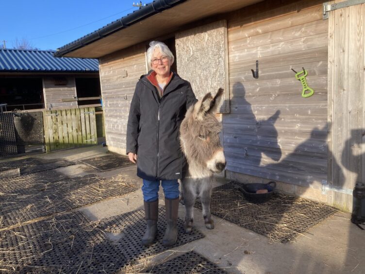 Rosie Dewhurst standing with Bob the donkey 