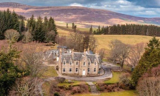 Aerial view of Glenliviet House in Ballindalloch with the hills and the background and the countrside surrounding it.