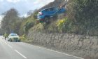 Car hanging over ledge near Drumnadrochit. Image: Katie Paterson.