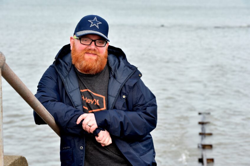 Chris Jappy pictured at Aberdeen beach wearing a blue jacket and hat, with a ginger beard.