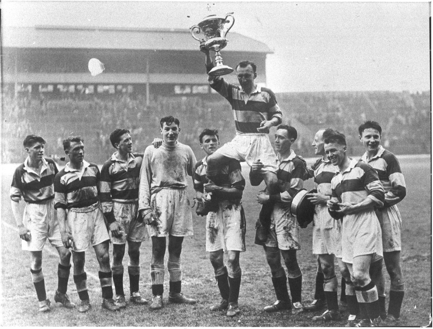The Banks o' Dee team lifting Jimmy Warrender who holds up the Scottish Junior Cup after Andy Walker's goal secured a 1-0 win. 