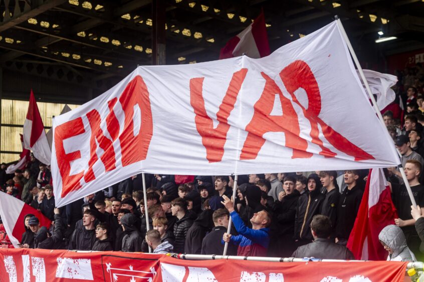 Aberdeen fans hold a sign saying "END VAR" during the match against Dundee at Pittodrie