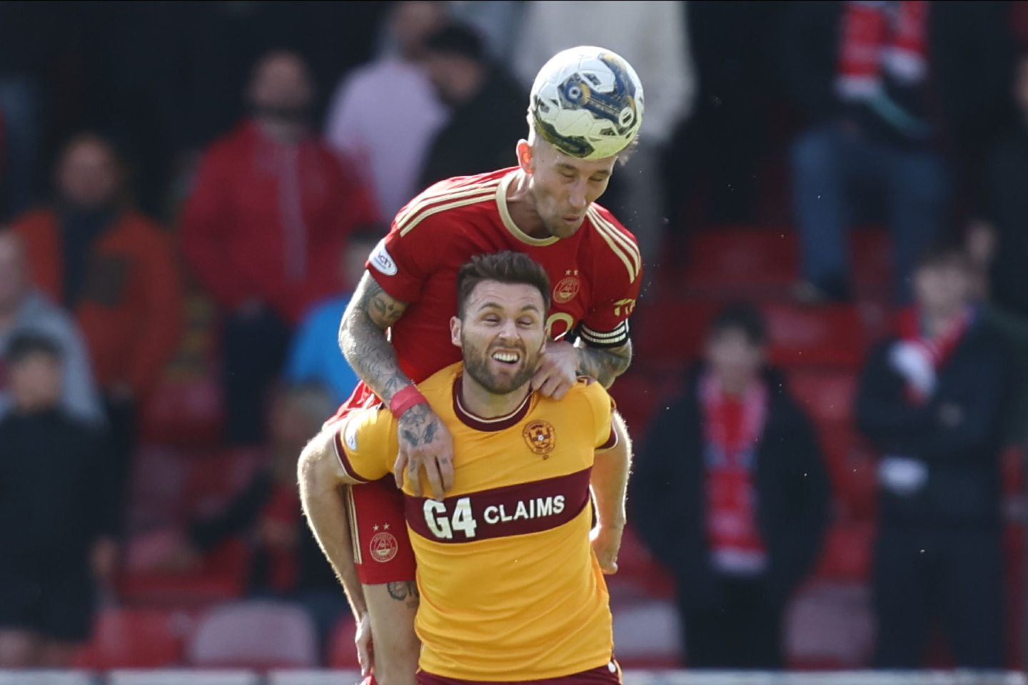 Angus MacDonald of Aberdeen and Motherwell's Blair Spittal battle for the ball. Image; Shutterstock