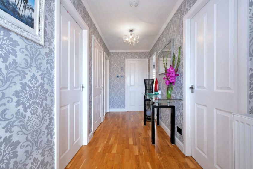 The hallway in the Newmachar home renovation with wooden floors and papered walls