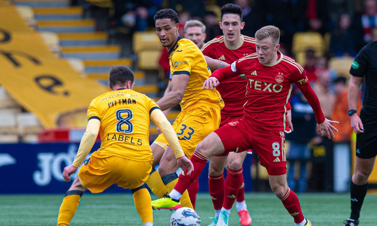 Aberdeen's Connor Barron takes on Livingston's Scott Pittman. 