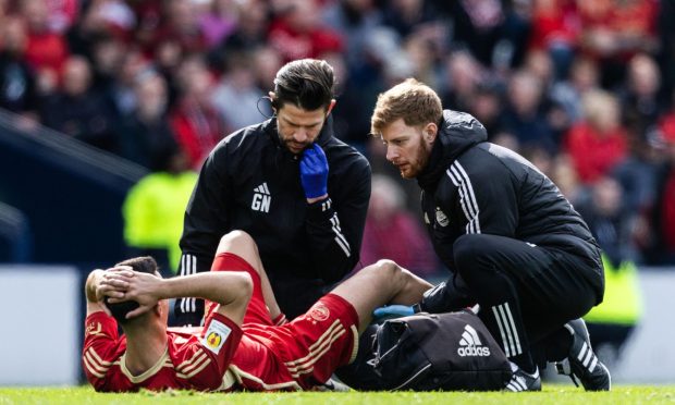 Aberdeen's Bojan Miovski receives medical attention during the Scottish Cup semi-final against Celtic. Image: SNS