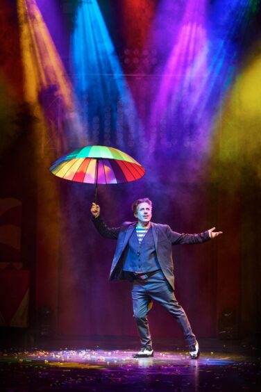 Christian Lee holds a colourful umbrella during the performance at Eden Court, Inverness.