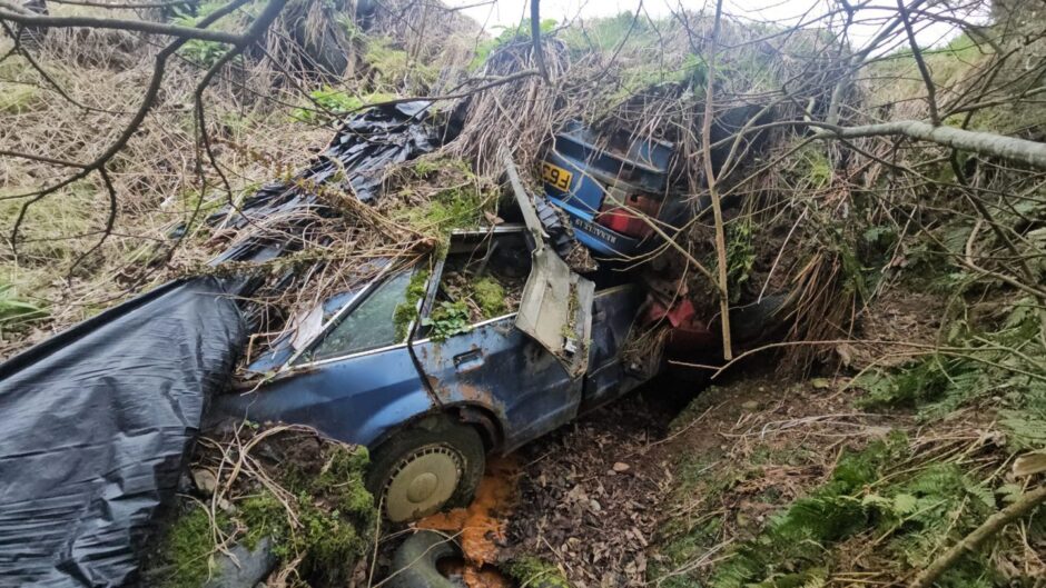 Renault 19 by a Vauxhall Nova found in the woods in Buckie.