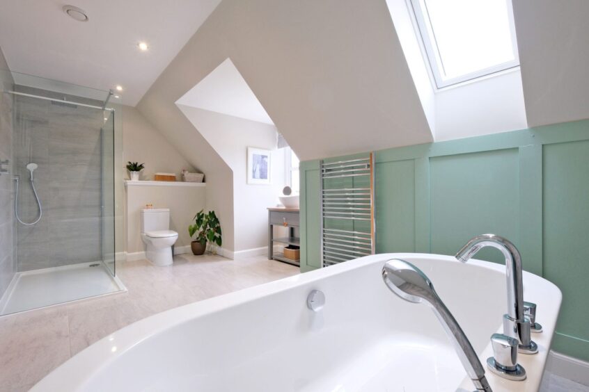 A bathroom in the Royal Deeside home, which has a standalone bath and walk-in glass cubicle shower. The colour scheme is white, grey and pale green