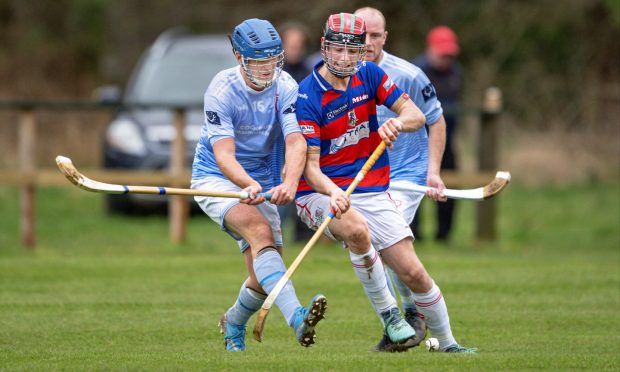 Ruairidh MacKinnon (Caberfeidh) with Cameron Bremner (Kingussie).  Image: Neil Paterson.