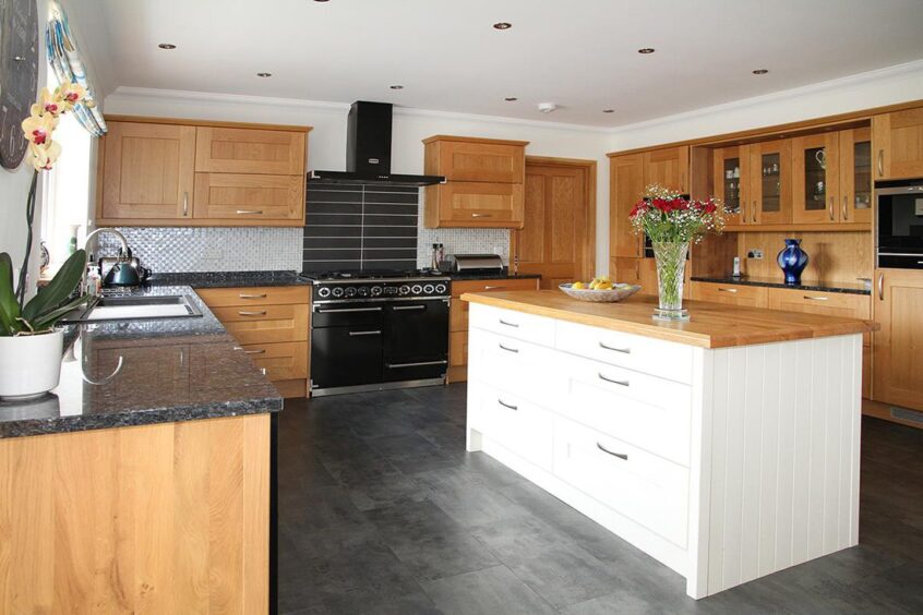 kitchen with wooden cabinets, black hob and huge white island