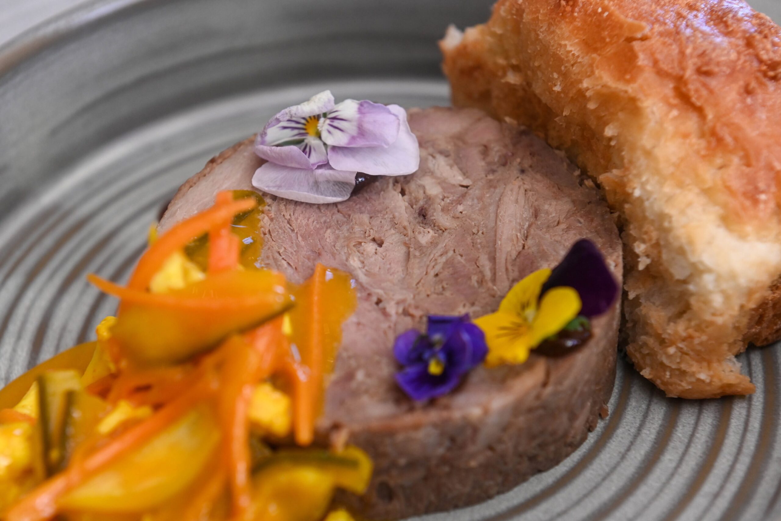 Close up of the confit duck leg terrine, served with brioche, piccalilli and teriyaki gel.