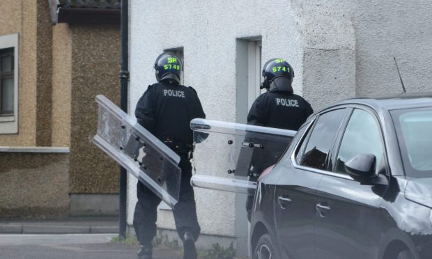 Police with riot shields at the scene in Inverness. Image: Supplied.