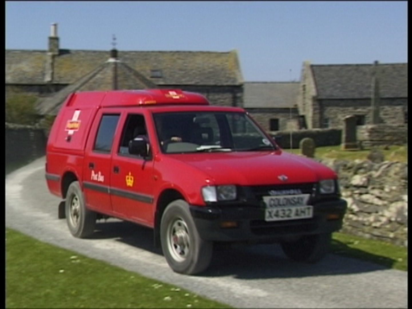 The Colonsay Post bus in front of some cottages