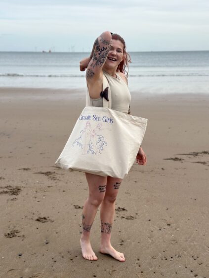 Mya holds a Granite Sea Girls tote bag.