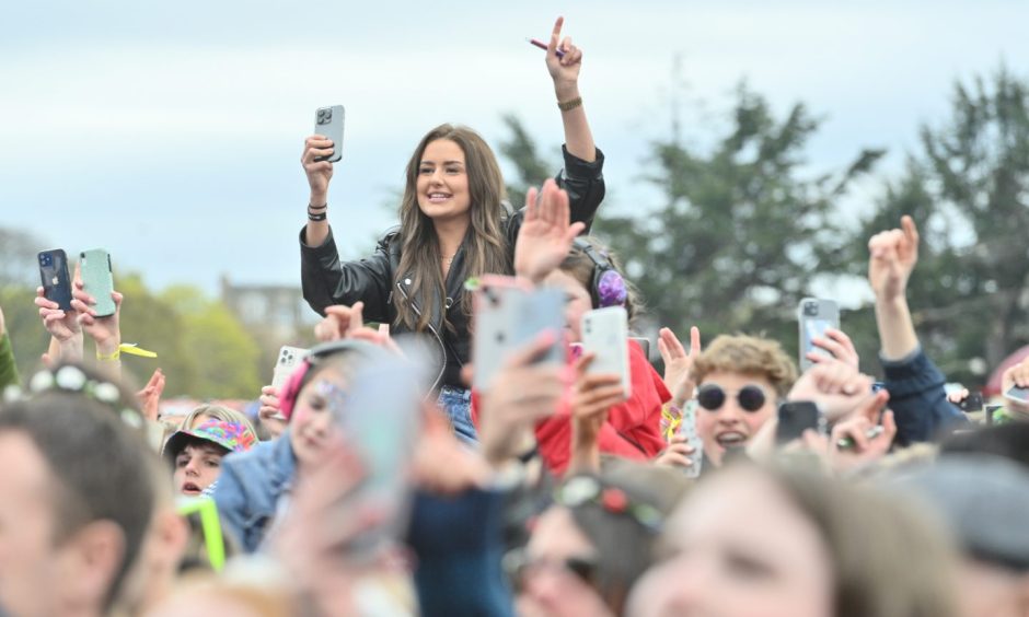 View across MacMoray Festival crowd with fans holding up mobile phones.