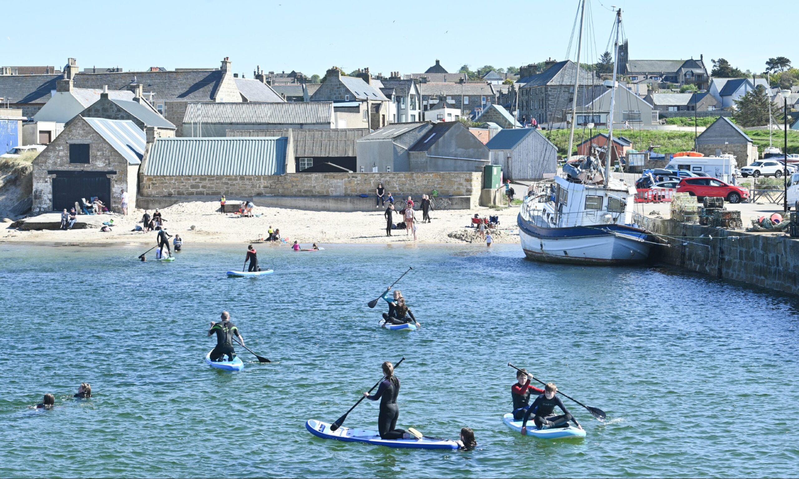 Hopeman harbour with paddleboarders. 