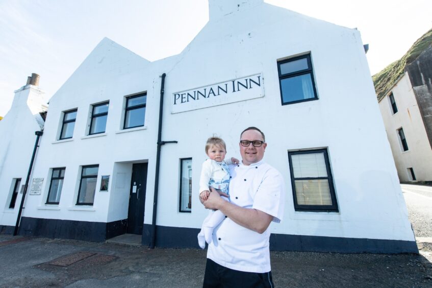 Peter Simpson holding son Carmen outside the Pennan Inn.