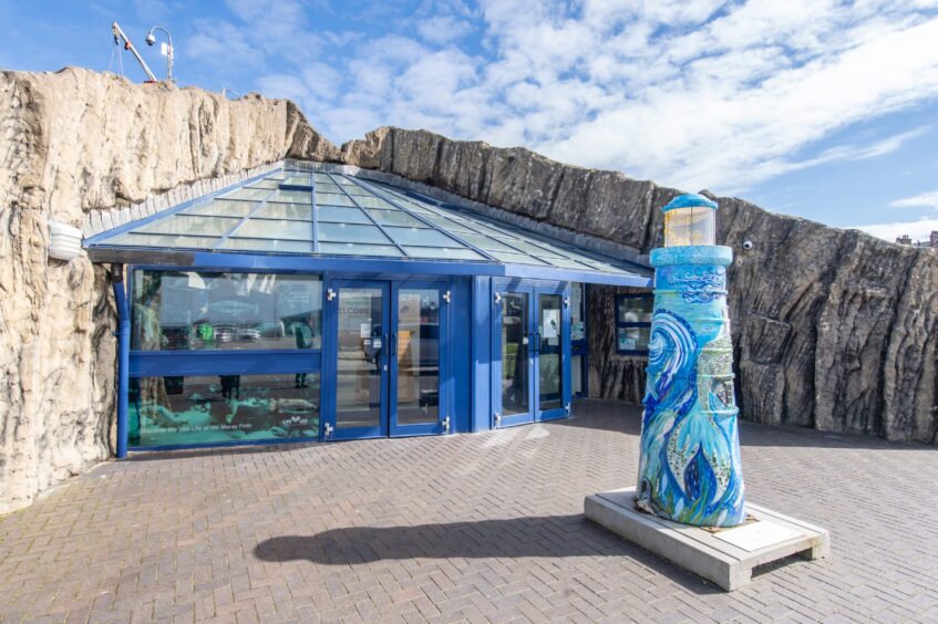 The entrance to the Macduff Marine Aquarium with a lighthouse sculpture outside.