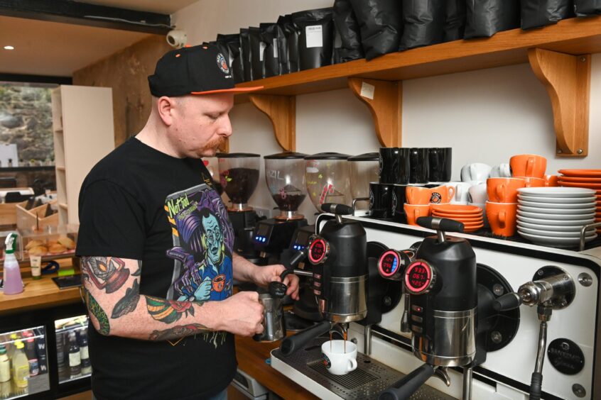 Nick, owner of the Red Robin Records Vinyl Cafe making a coffee at the machine. 