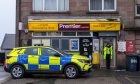 A police officer stands outside the Premier Express at the scene in Peterhead. Image: Kenny Elrick/DC Thomson