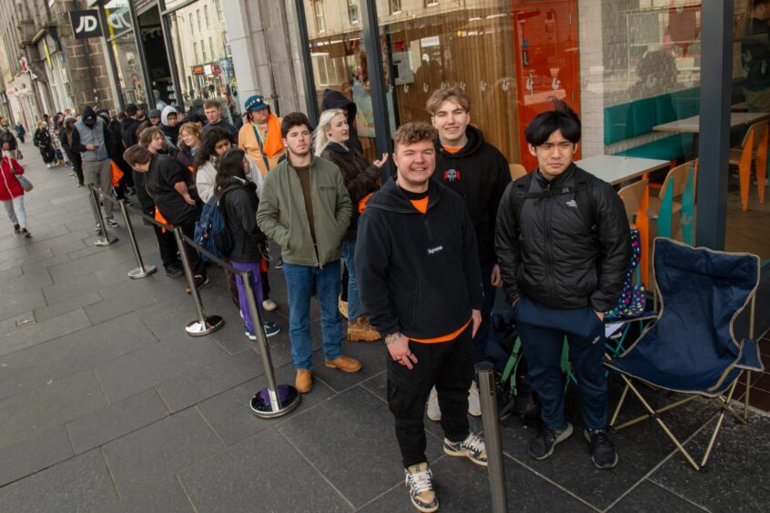Queues of people wait along Union Street for the opening of Popeyes