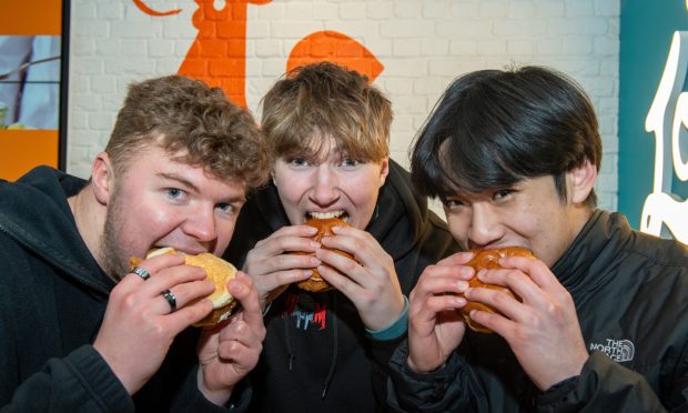 Josh Sim, Nathan Johnston and Vincent Choi - the lucky winners of free chicken sandwiches for a year. Image: Kenny Elrick/DC Thomson.
