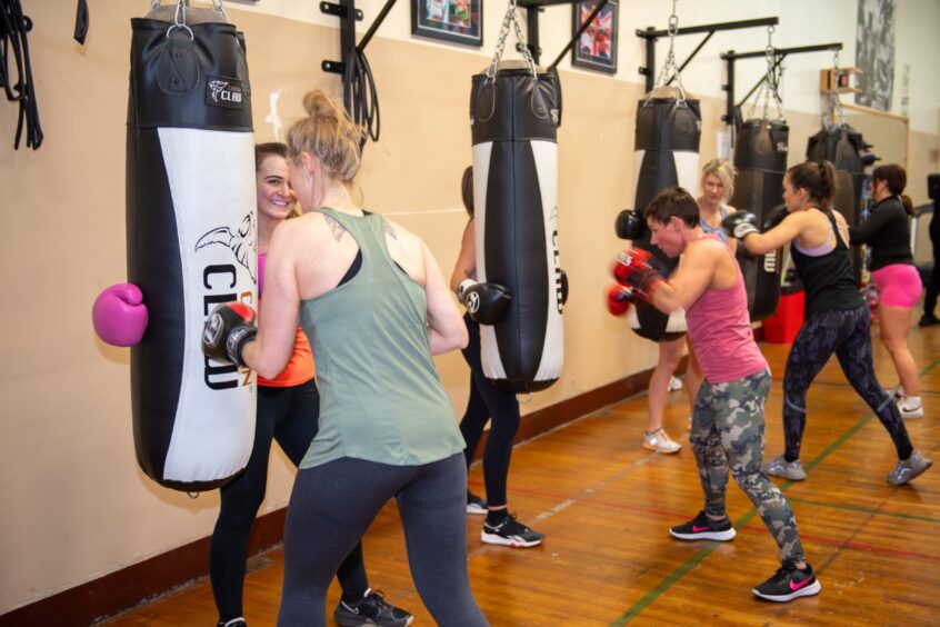 Women punching bags during boxing class in Aberdeen.