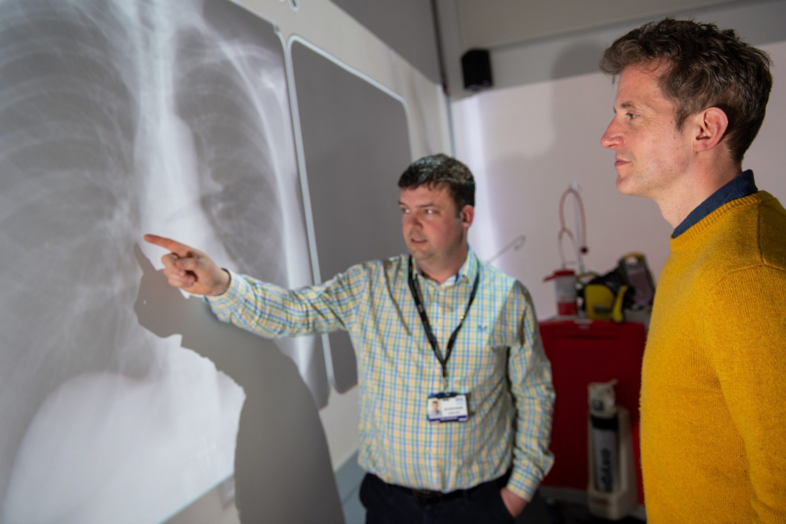 Craig pointing at a projection of an X-ray