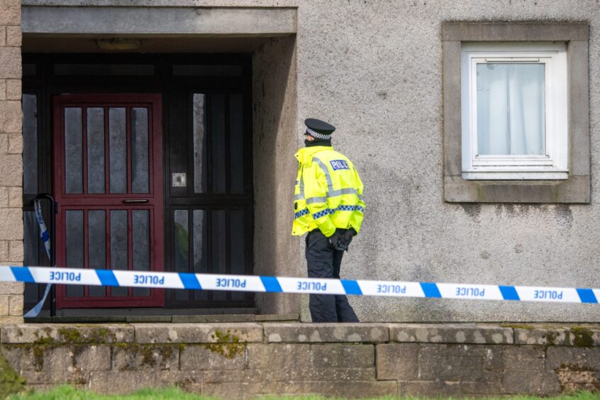 Police enter a building in Tillydrone where a woman died.