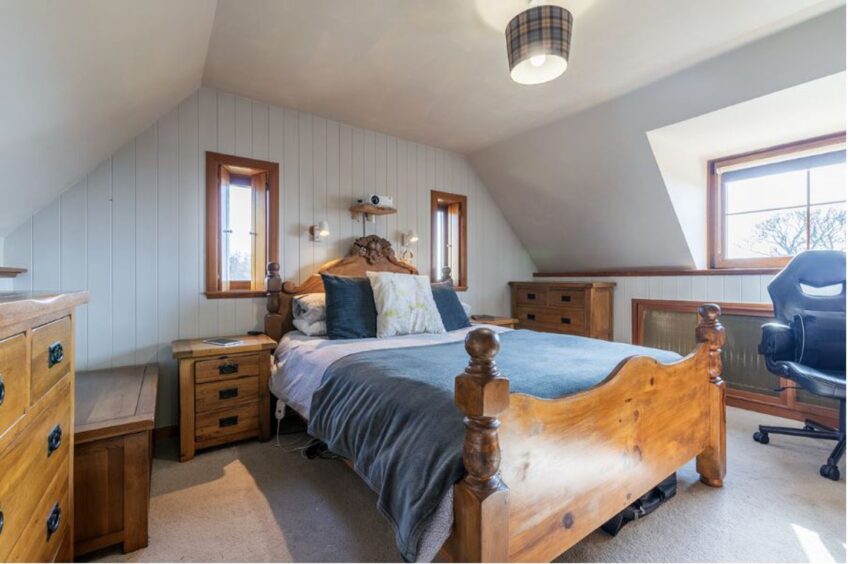 Blue bedding complements the solid wood furniture and head board in the master bedroom.