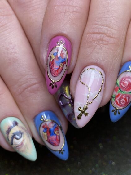 One of the Aberdeen nail artists designs featuring pink, purple and green Stiletto nails with unique artwork.