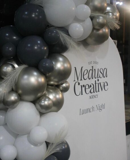 A banner surrounded by balloons reading 'Medusa Creative agency - launch night'