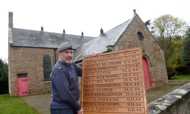 Sgt John Le Huquet from RAF Lossiemouth with one of the the memorial boards outside Petty Church. Image Sandy McCook/DC Thomson