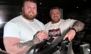 Tom and Luke Stoltman smiling at camera in the gym.