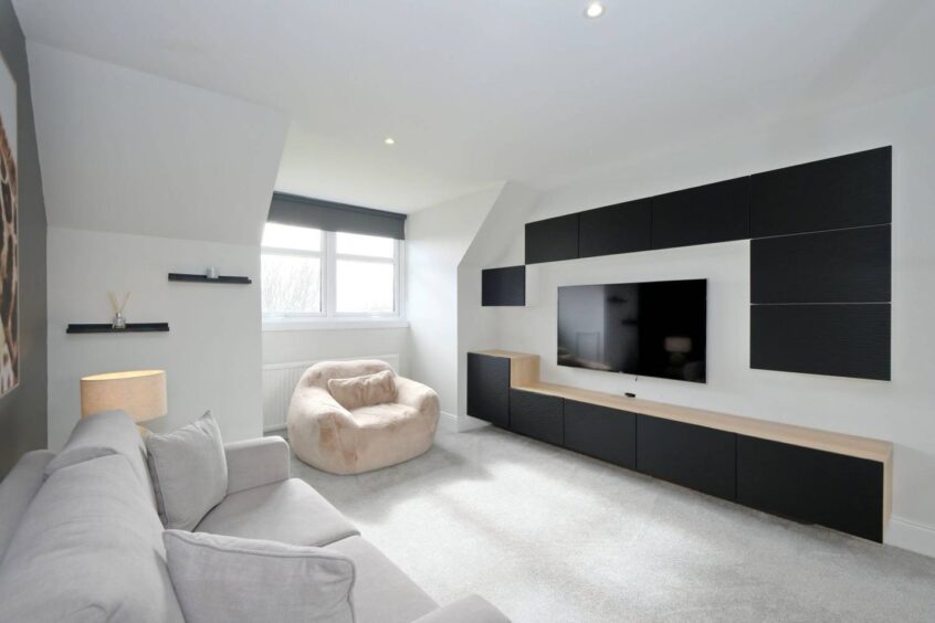 Room with sofa and TV and units on wall