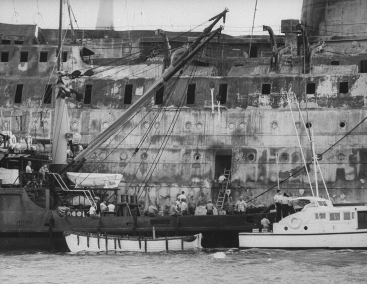 Workers climb aboard Viking Princess after the fire at Port Royal, Jamaica. 