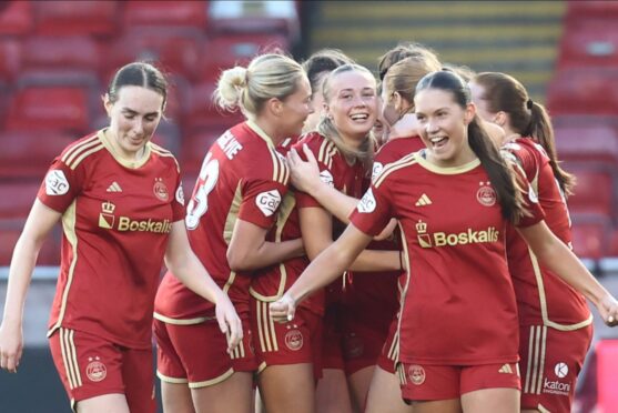 Hannah Innes, centre, smiles after scoring to make it 2-1 to Aberdeen against Montrose. Image: Shutterstock