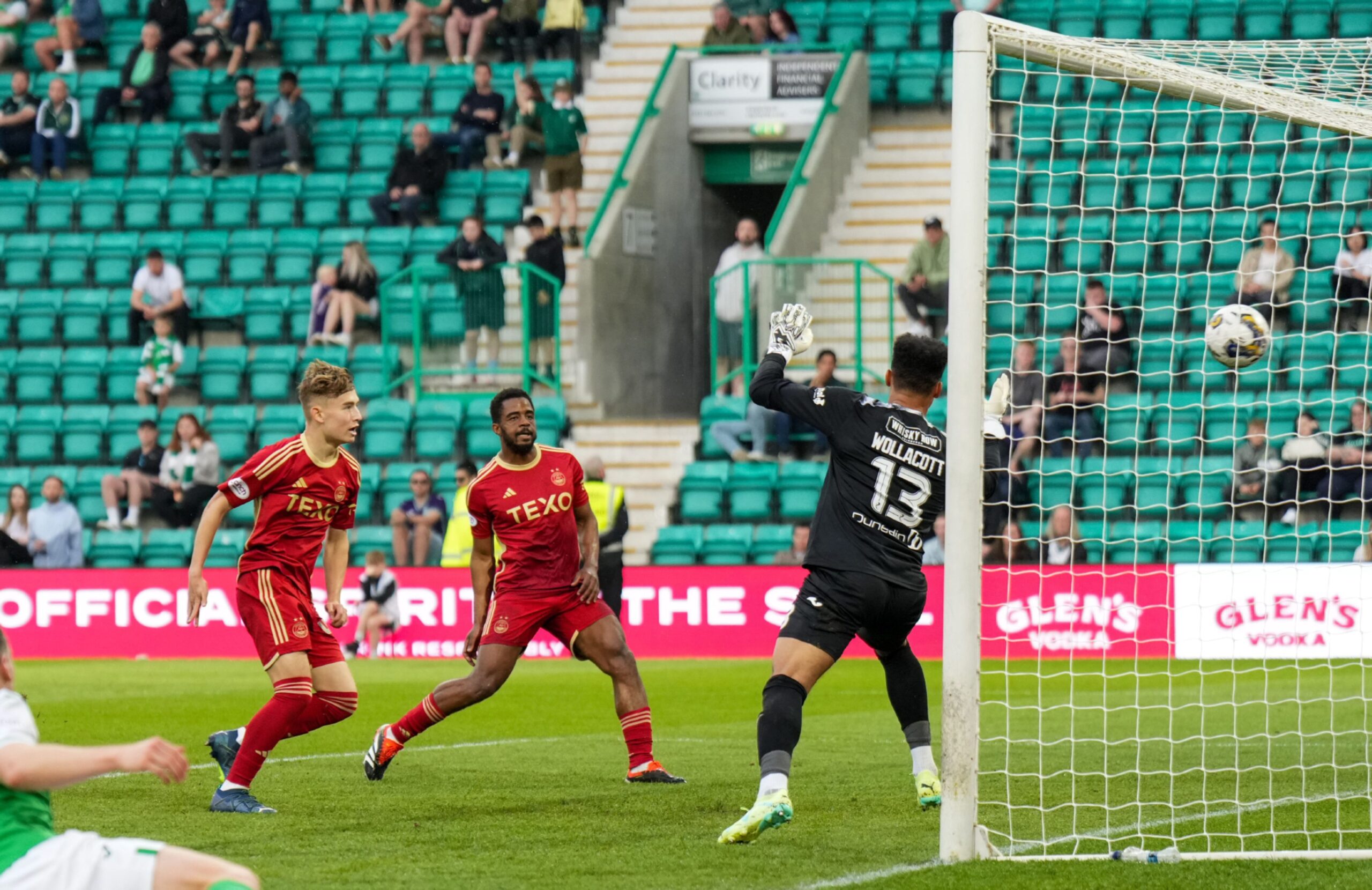 Fletcher Boyd of Aberdeen scores past Hibernian goalkeeper Jojo Wollacott on his first team debut. Image: Shutterstock 