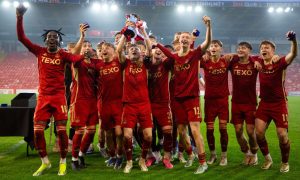 Aberdeen's players lift the Club Academy Scotland Elite U18s league trophy at Pittodrie on Monday night. Image: Shutterstock.