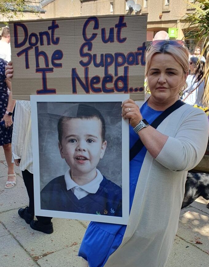 Lynn Prise holding a banner with photo of her son Woody. 